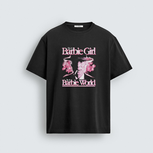 A black unisex t-shirt featuring a graphic print of Oppenheimer enveloped in pink smoke with the text I'm A Barbie Girl In A Barbie World in a stylized pink font.