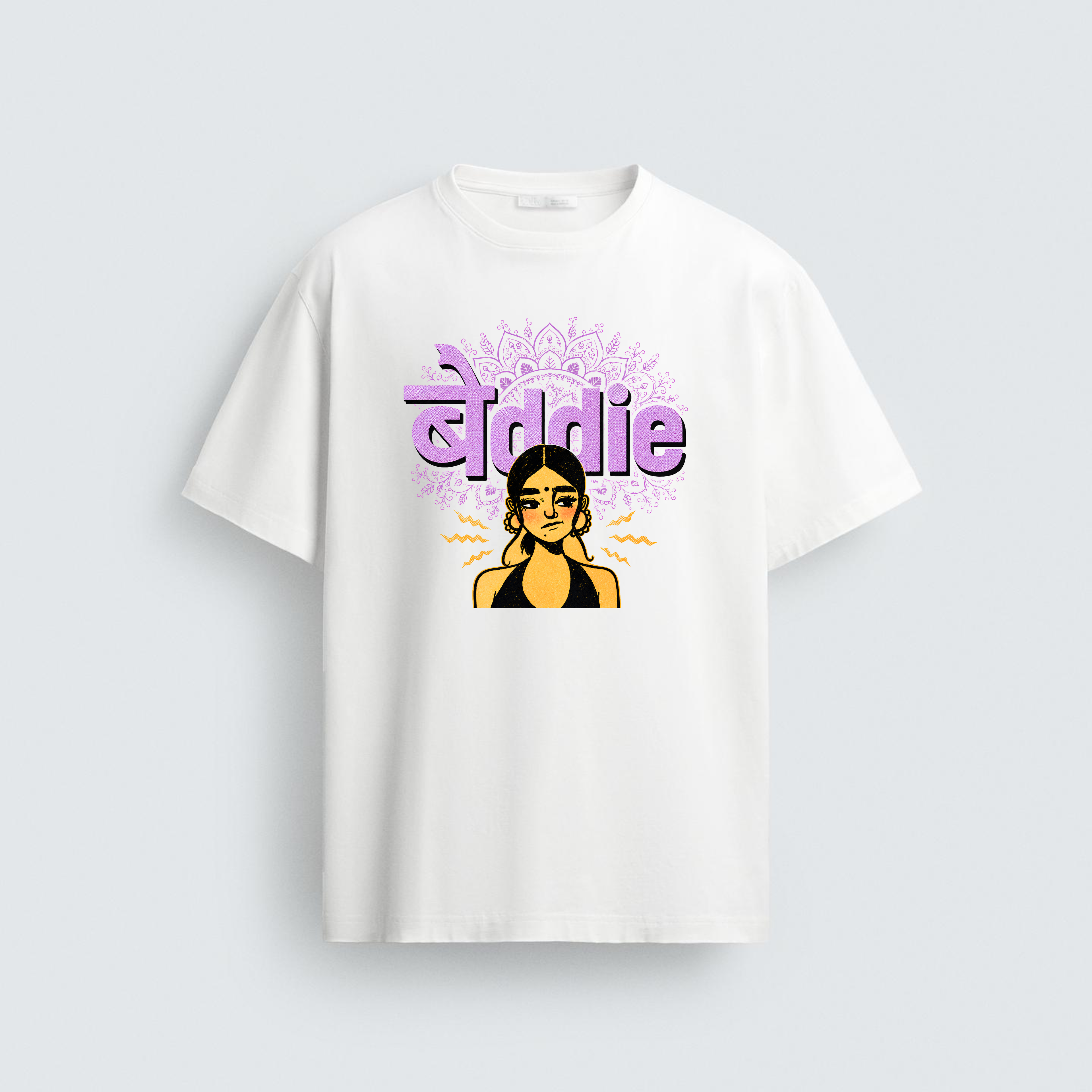 A white t-shirt featuring a graphic illustration of a skeptical South Asian woman with a bindi and hoops under the fusion text "बेddie" in purple color 