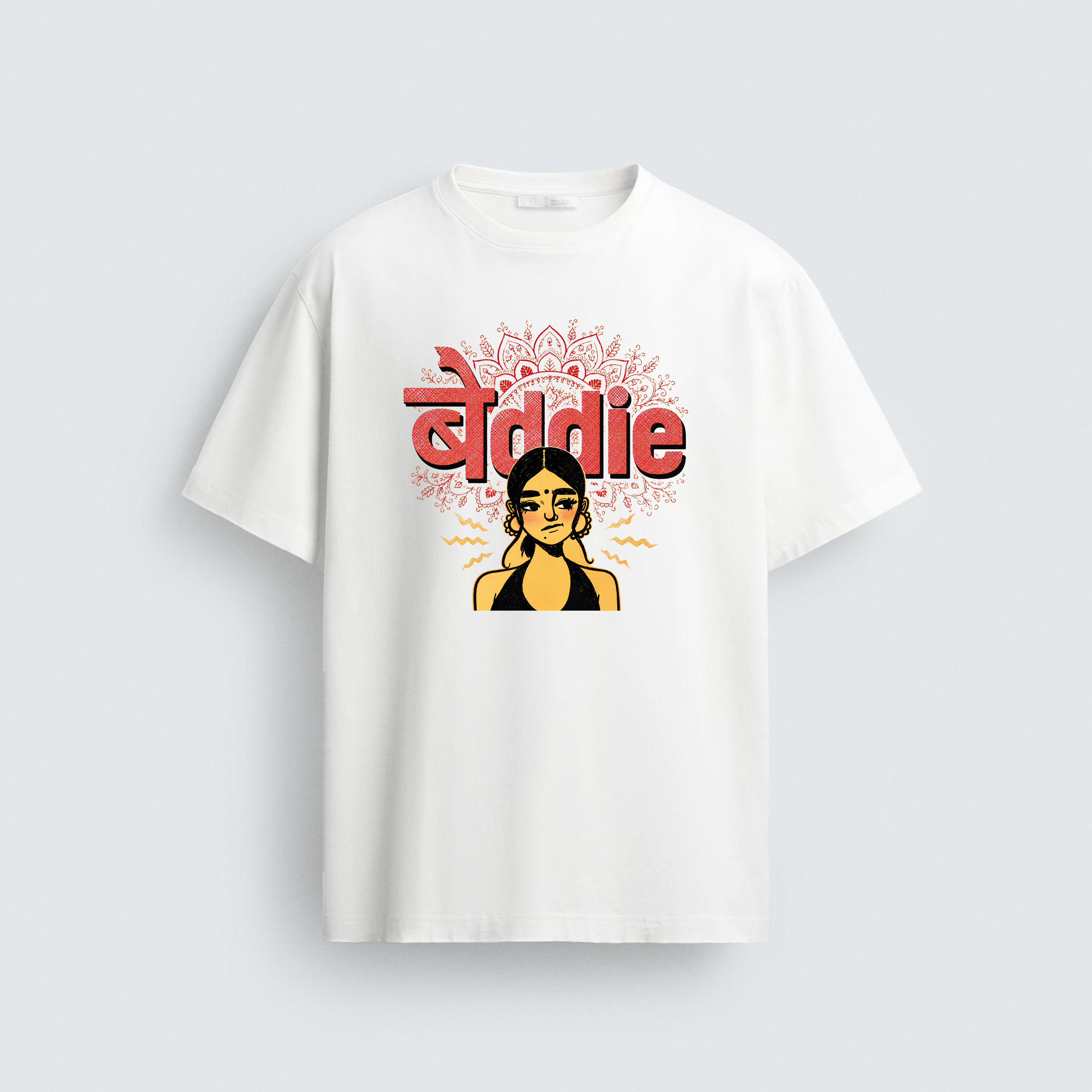 A white unisex t-shirt featuring a graphic illustration of a skeptical South Asian woman with a bindi and hoops under the fusion text "बेddie" in purple and red color options.