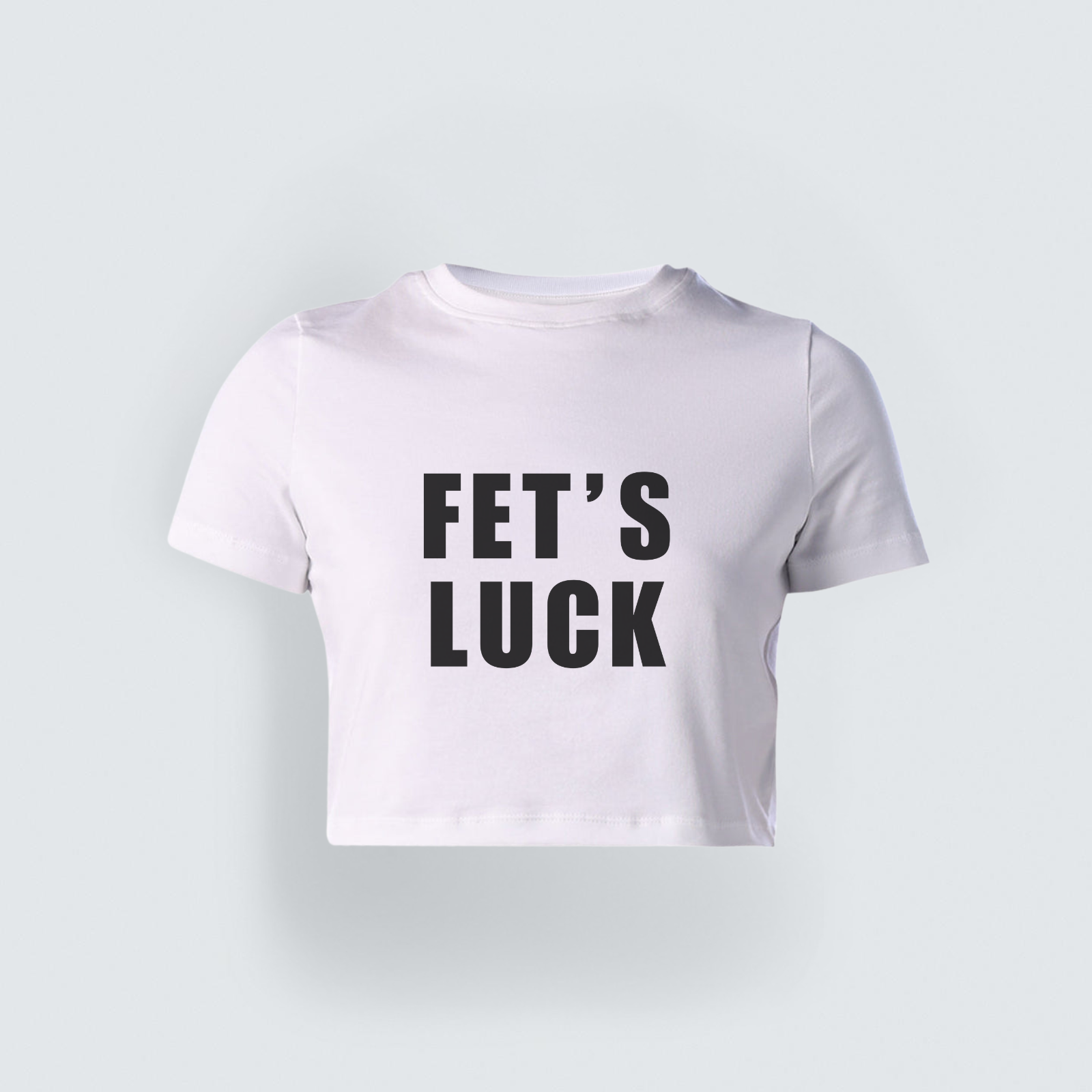 A white short-sleeved cropped baby tee featuring the text 'FET'S LUCK' printed in bold, black capital letters across the chest, displayed on a clean light gray background.