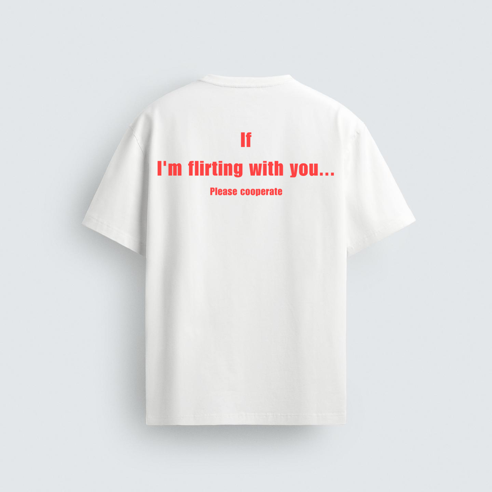 The back view of a white unisex t-shirt featuring bold red text centered on the upper back that reads, "If I'm flirting with you... Please cooperate."