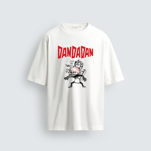 A photograph of a plain white oversized cotton tee from image_0.png. In the center, a graphic shows the jagged red text "DANDADAN" above a punk-style black and white illustration of two aggressive characters with spiky hair, dynamic and shouting.